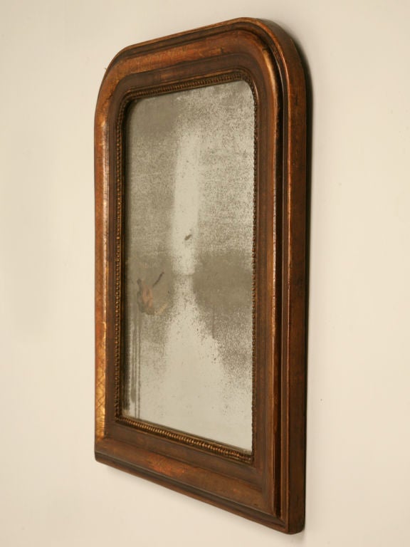 Awesome petite early 19th century French Louis Philippe mirror with it's original warm worn patina. An unusual size makes this fine mirror a perfect mirror the perfect fit for many places. The rich tones of the frame are complimented by the