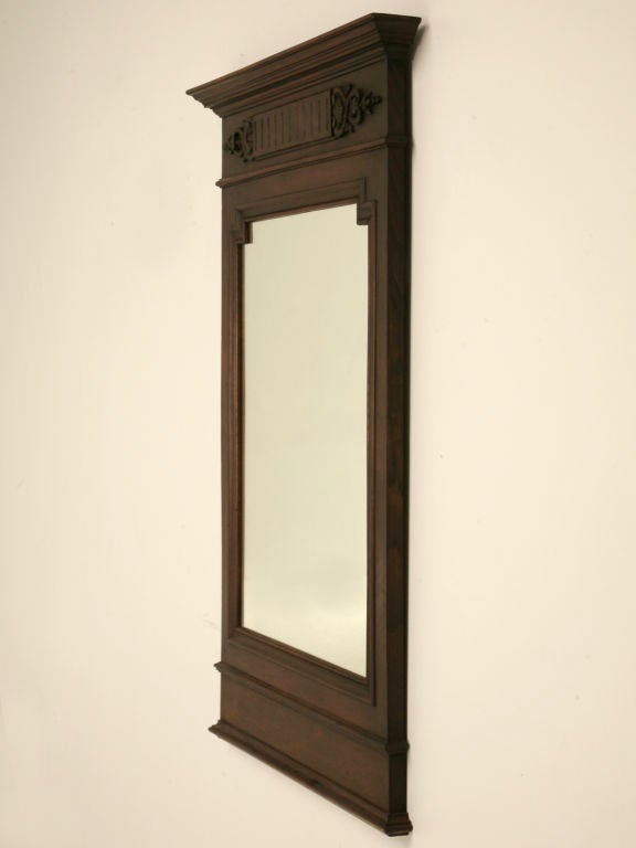 Stately antique French walnut mirror with a fine aged patina. Endless possibilities for this clean lined mirror with just a bit of carving and fluting near the crown, a great mirror, don't miss it.