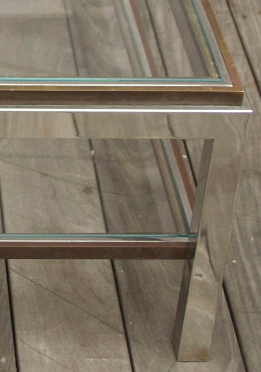 A square two-tiered stainless steel coffee table with flush glass surfaces inset in steel frame, surrounded by contrasting patinated bronze frame. Signed by designer, Willy Rizzo*. Hand-made in his Roman workshops.<br />
<br />
*Willy Rizzo was a