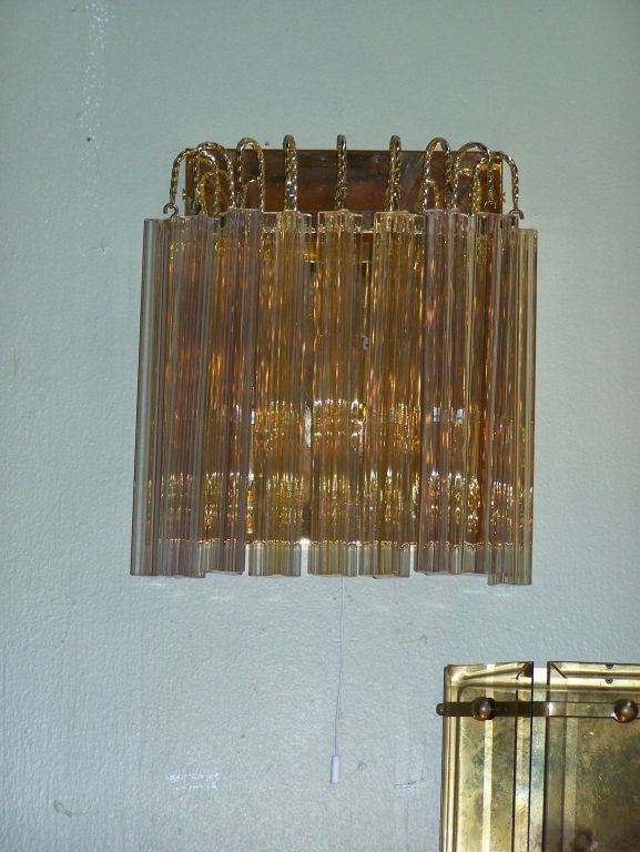 Pair of clear and yellow glass sconces. Three lights each