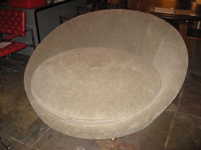 Modern oval chair on casters.  Upholstered in grey chenille fabric.  A cozy seat for two.