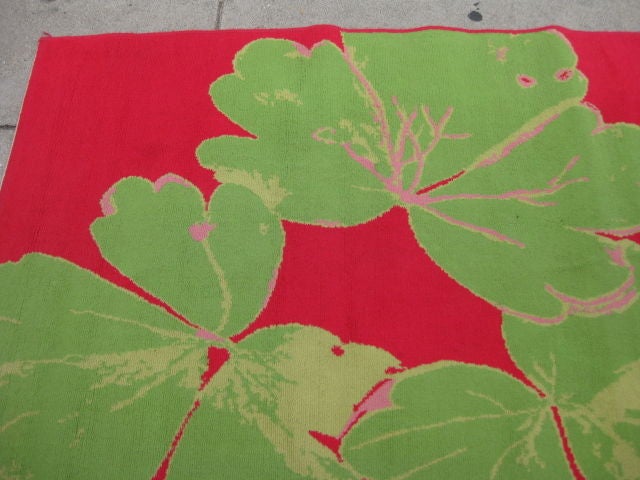 Art Deco vibrant pink area rug with green leaf detail.