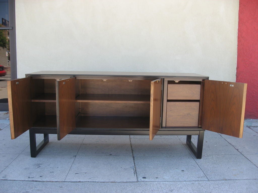 This credenza is made of walnut with black trim and base.<br />
What made this cabinet unusual is its narrow depth.<br />
Very well made.