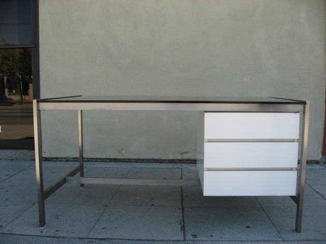 The frame is nickel, the drawers made of white formica and the top is a smoked glass.