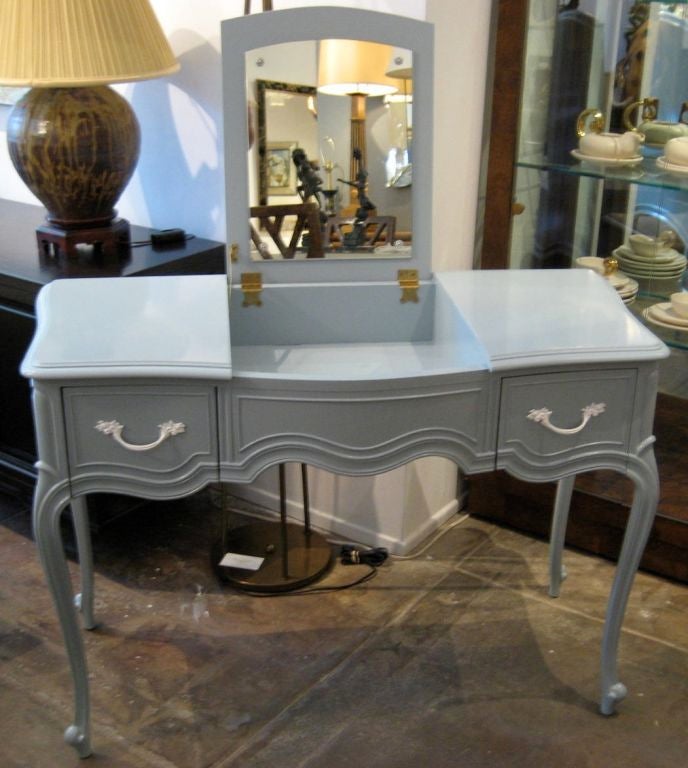 Charming French style vanity refinished in light Sea Blue lacquer with white period hardware.  The piece is beautifully carved and finished on all sides.