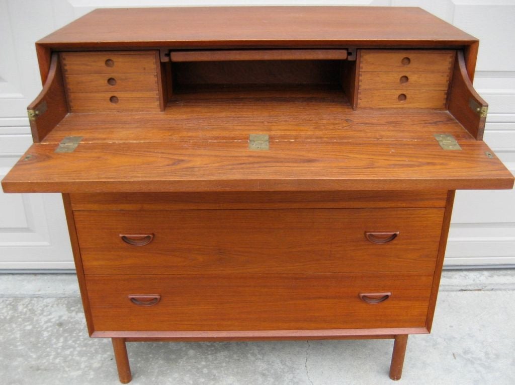 Masterfully crafted Teak chest with vanity mirror and accessory drawers by Peter Hvidt / Soborg for John Stuart, Inc., NY.  Cabinet features finger joinery and distinctive sculptural inset pulls.
