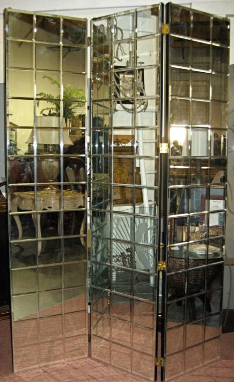 Three panel folding screen consisting of trellis pattern beveled cut mirror. Dimensions: Each panel measures 18