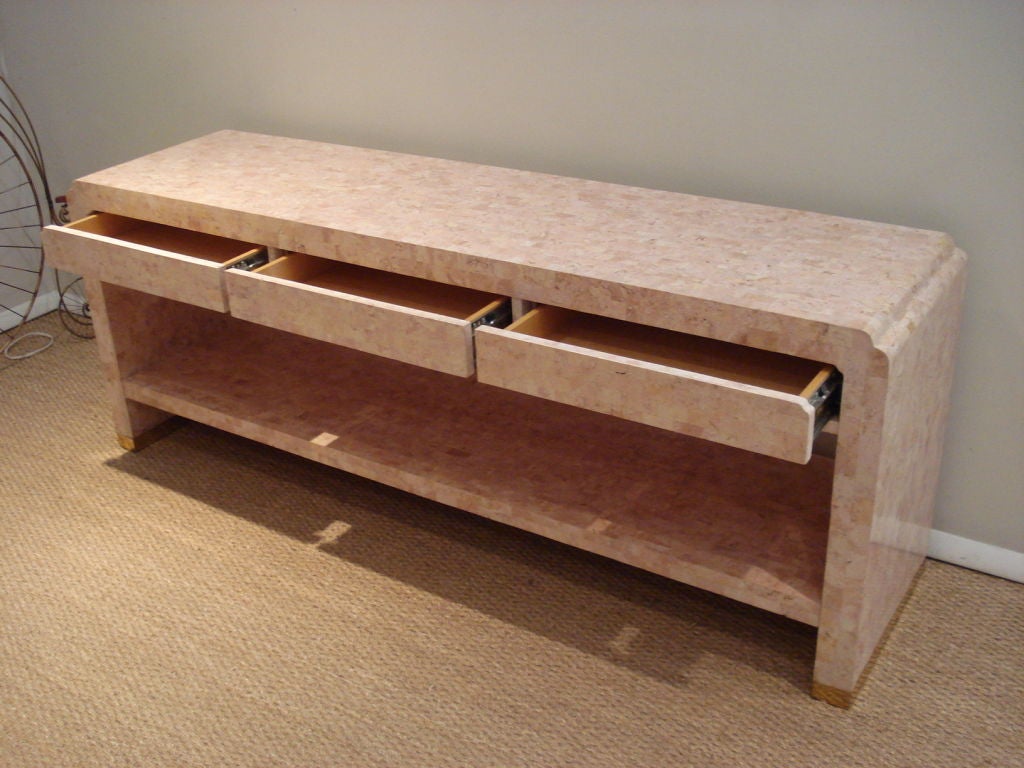 Unusual travertine tile wrapped 2 tiers console. Three drawers, brass plinth. Great proportion.