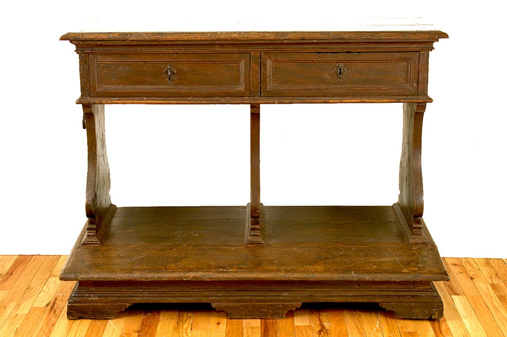 having a one board solid walnut top with molded edge above a conforming case housing two locking drawers set above three lyre-form supports resting on a slightly slanted kneeling surface and resting on bracket feet, used for prayer and finished on