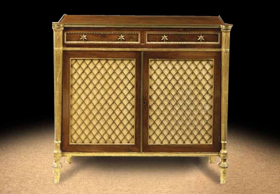 A fine Regency rosewood side cabinet in the manner of John McLean. The rectangular eared top with boxwood stringing above two short frieze drawers and two bass grille doors enclosing an adjustable shelf, flanked by reeded columnar supports on toupie
