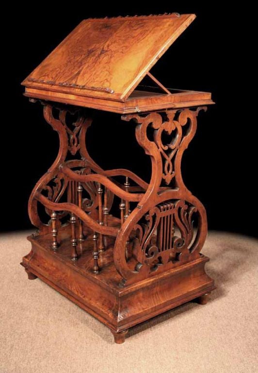 Victorian Circassian walnut music stand / lectern, having a hinged adjustable top raised on pierced lyre form supports, with spindle dividers for magazines and music, etc. over a rectangular ogee plinth with secret drawer. <br />
In the “Cabinet