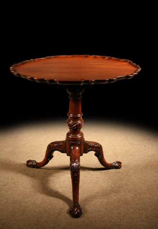 #S018, Mid-Georgian mahogany piecrust table having pleasing, well-balanced proportions. Note the carved details including the tilt-top with it’s shapely scalloped edge. Raised on a turned column support and a spiral fluted vase, ending in carved