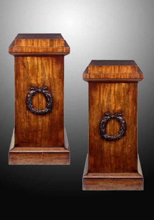 # Q548 - Pair of Regency mahogany pedestals. The doors centered by ribbon tied laurel garland, one pedestal enclosing two shelves, the other enclosing a drawer with divisions, a shelf and a lead lined drawer, the hinges stamped