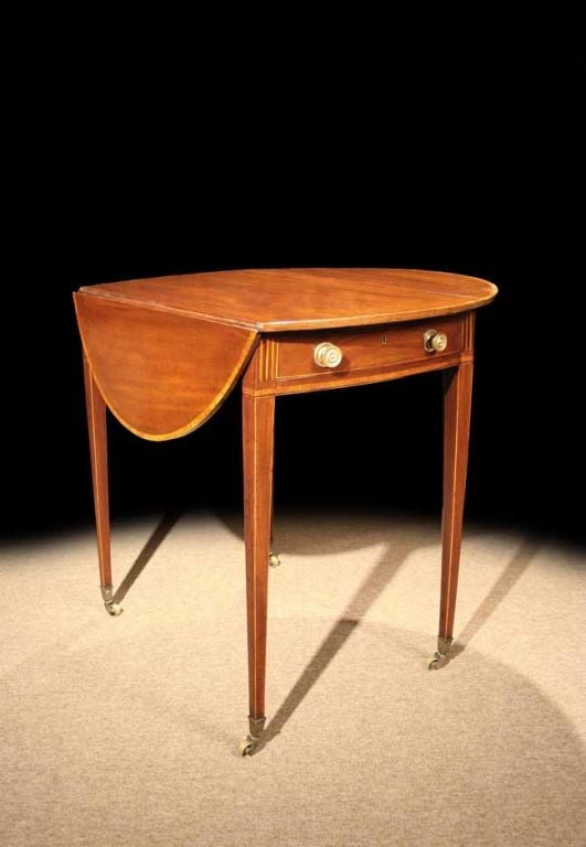 # Q540 - George III oval Pembroke table (named after the Earl of Pembroke who reputedly ordered the first one) executed in beautifully grained mahogany and enriched with tulipwood inlays. The oval top with a crossbanded border all around. The frieze