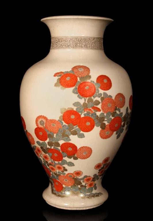 Meiji period earthenware vase artistically painted in polychrome enamels and gilt depicting a decorative arrangement of chrysanthemums. The molded neck with an openwork band of phoenixes and flowers.

See “Japanese Porcelain” by Schiffer, page