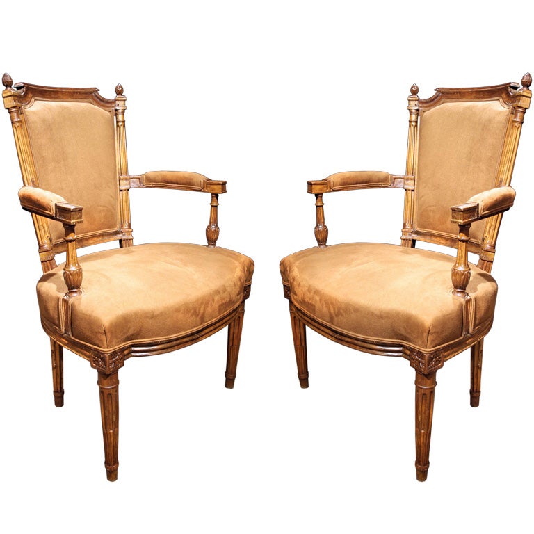 # H081 - Elegant and well proportioned PAIR of Louis XVI carved beech wood fauteuils in the neoclassical taste. The rectangular shaped backs with cut corners and surmounted by ball finials. The open arms with carved stop fluted baluster supports.