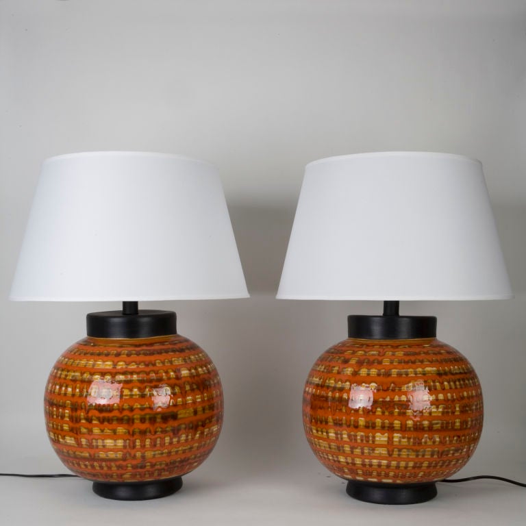 A pair of orange ceramic table lamps