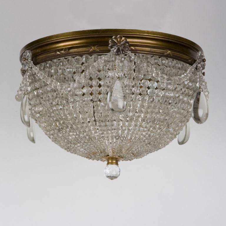 HL3231<br />
A beaded basket flush-mount fixture with a border of swags and teardrop prisms. Having age-darkened reed and ribbon detailed bronze fittings. Signed by the maker Sterling Bronze Company.<br />
<br />
Height: 8 3/4