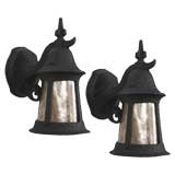A pair of black enamel exterior wall lanterns