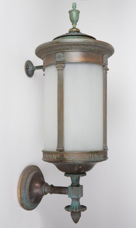 A pair of verdigris bronze cylindrical wall lanterns