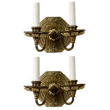 A pair of two arm brass sconces by E.F. Caldwell
