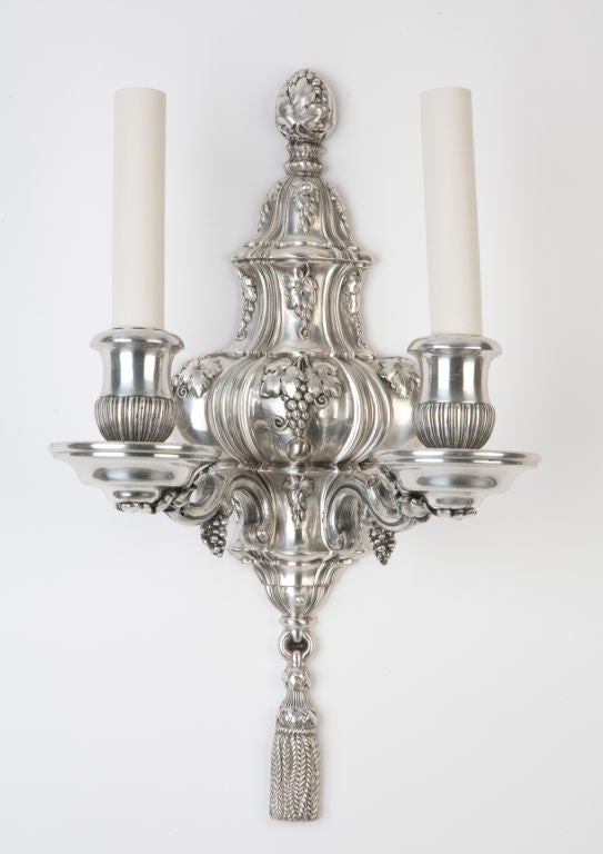 AIS2539

A pair of silver two arm sconces with finely chased grapevine details by the maker E. F. Caldwell.

Backplate: 16 1/4