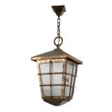 A large hammered bronze lantern with frosted glass.