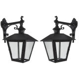 A pair of black enameled brass wall lanterns
