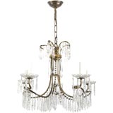 A five arm crystal chandelier in an antique brass fin