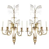 A pair of three-arm gilt brass sconces