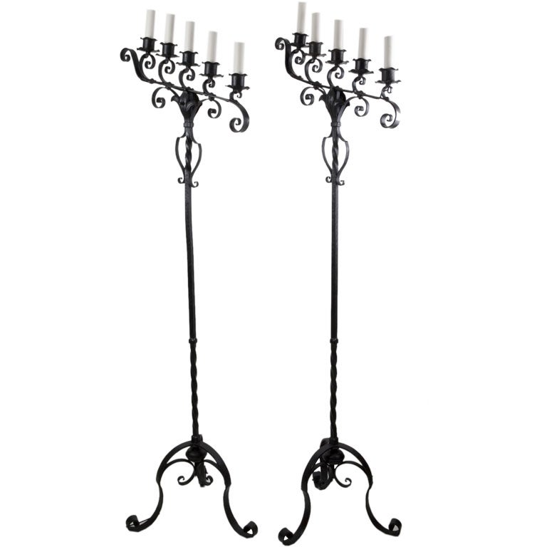 A pair of black iron candelabra floor lamps