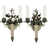 A pair of tole two arm sconces with porcelain flowers