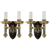 A pair of two-arm polished iron and brass sconces