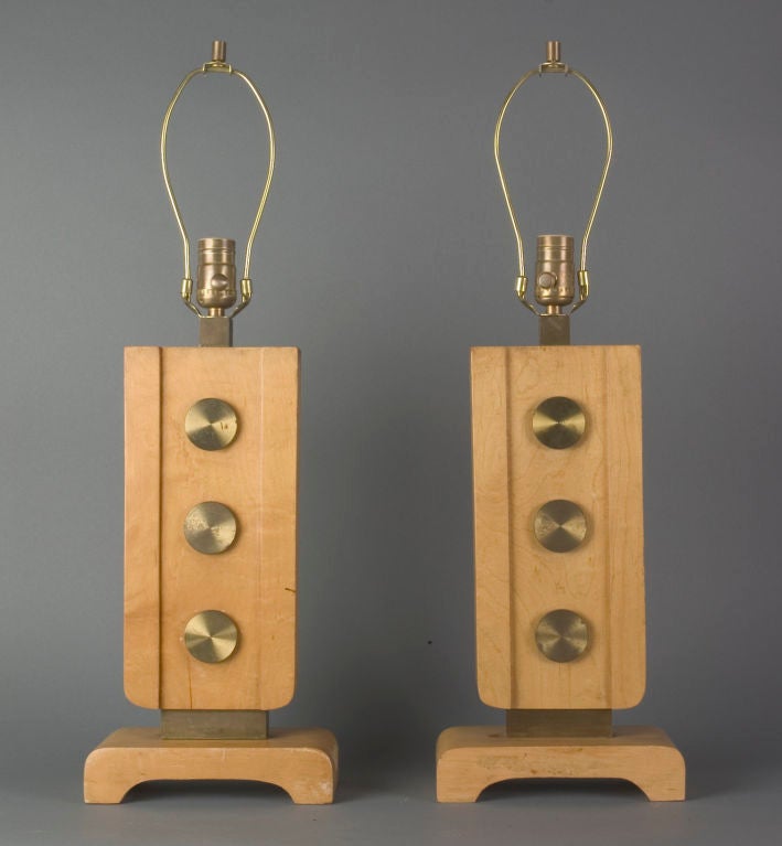 ATL1609<br />
A pair of blond wood table lamps accented with lacquered brass rondelles.<br />
<br />
Overall height: 25