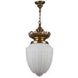 A large frosted glass pendant on foliate bronze hardware