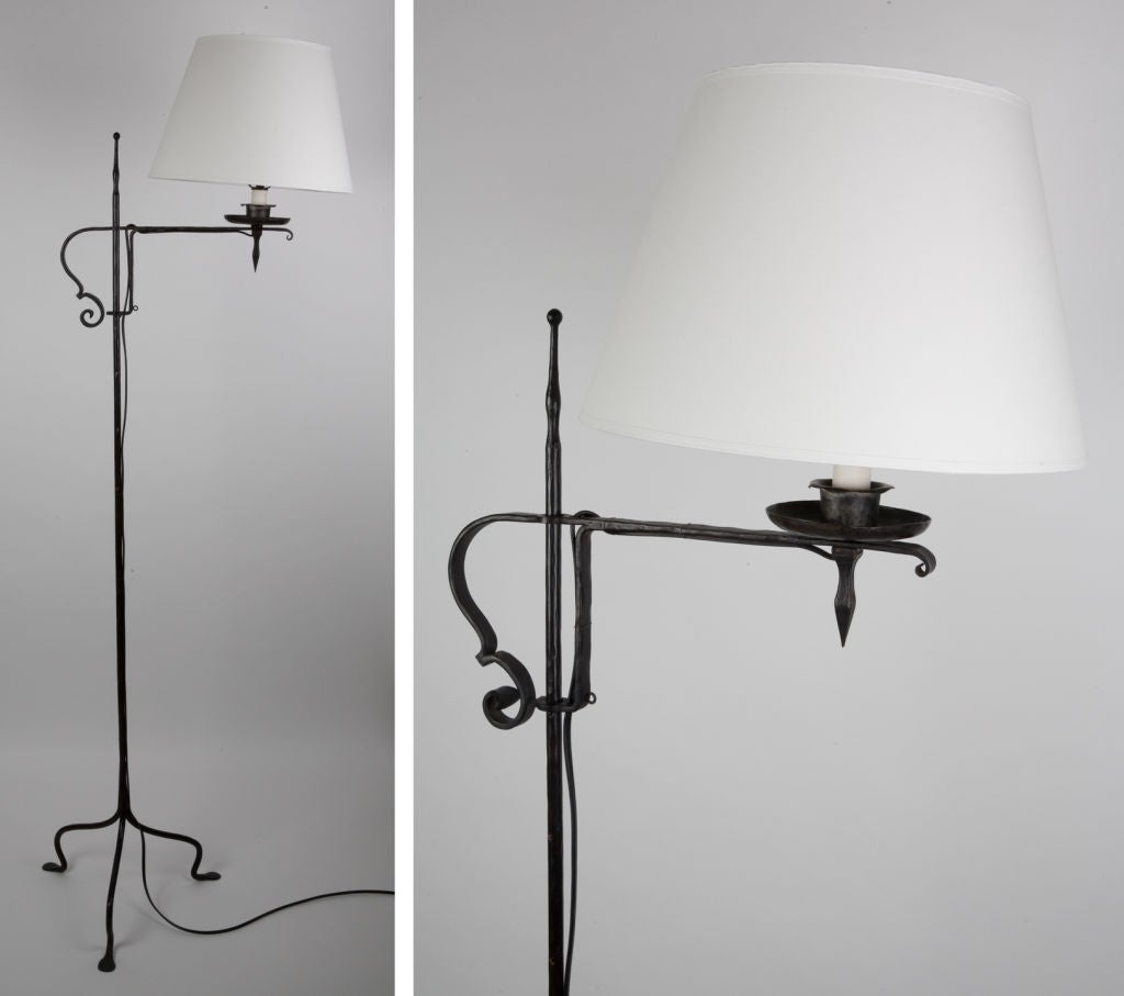 TF1714<br />
An adjustable height blackened wrought iron floor lamp with a bridge arm and a tripod base.<br />
<br />
Overall height: 65-1/2