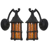 A pair of painted iron and amber glass exterior lanterns