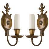 A pair of single arm sconces with flame finials