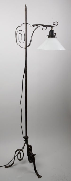 TF1646<br />
A wrought iron tripod based floor lamp with an adjustable arm and a white glass shade.  The shade fitted by the Remains Lighting Workshops.<br />
<br />
Height: 60