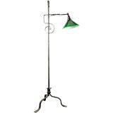 A wrought iron tripod bridge lamp