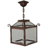 An antique copper lantern with beveled glass panels