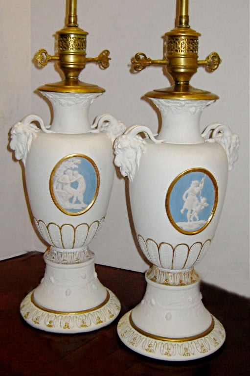 Pair of 1920s porcelain neoclassic table lamps with gilt details and Wedgwood plaques on body.
Measurements:
Height of body: 19''
Diameter: 7.5