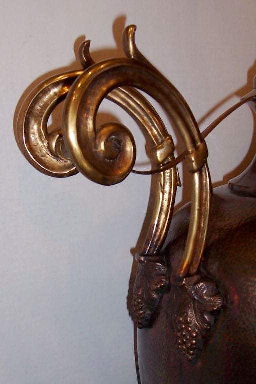 Zwei große italienische Tischlampen aus gehämmerter Bronze mit Originallackierung. Der Korpus ist mit Trauben und Blättern verziert und hat überdimensionale Griffe mit Schnörkeln.

Maße: 28,5