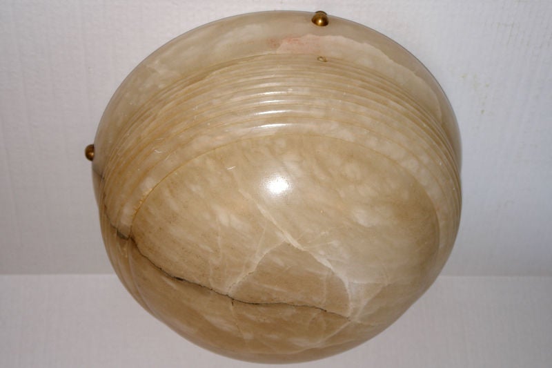 A circa 1940s French carved alabaster light fixture of neoclassic style, cream color with gray veining.

Measurements:
Depth 9.5