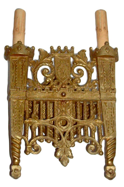 Ensemble de quatre appliques en bronze coulé et doré du début des années 1900, avec tourelles et bouclier sur le corps.