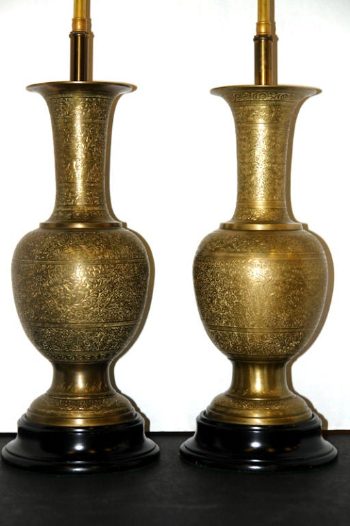 A pair of Moroccan circa 1920's etched brass vases mounted as table lamps with ebonized bases.

Measurements:
Height of body 16