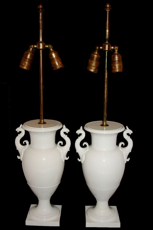 Pair of circa 1920s English white porcelain table lamps with griffins on body.

Measurements:
Height of body 15.5