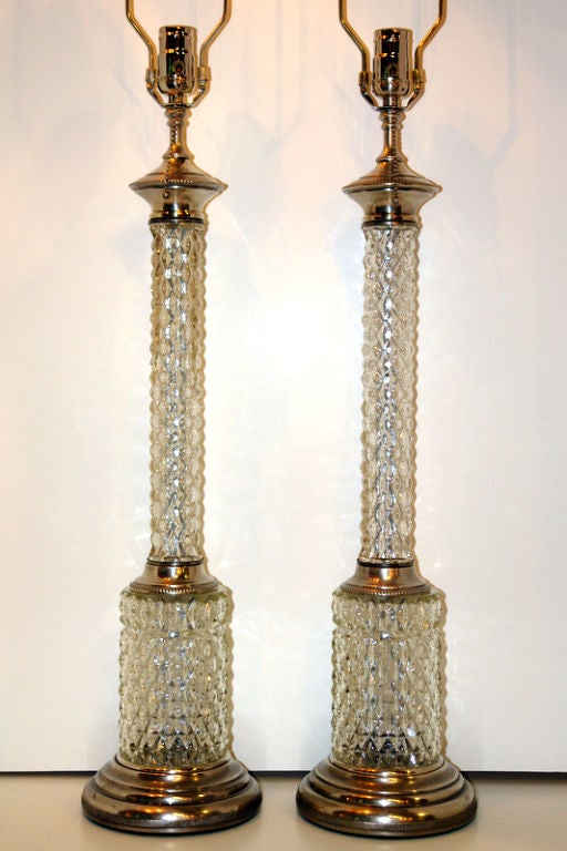 A pair of French circa 1930's molded glass table lamps with silver-plated base and hardware.

Measurements:
Height of body: 25