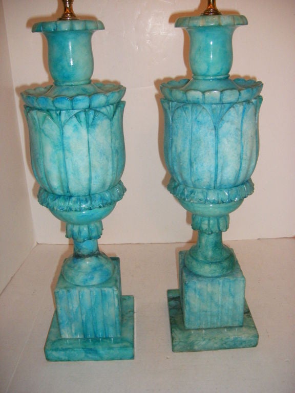 Pair of carved alabaster lamps with turquoise colored finish. The urn shaped body on a pedestal base.<br />
20