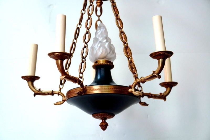 Circa 1900 French Empire-style chandelier with flame-shaped glass light in the center. 

Measurements:
Diameter: 22